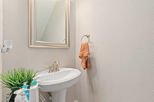 bathroom with a textured wall and a sink