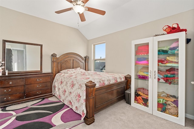 bedroom with light colored carpet, vaulted ceiling, and ceiling fan