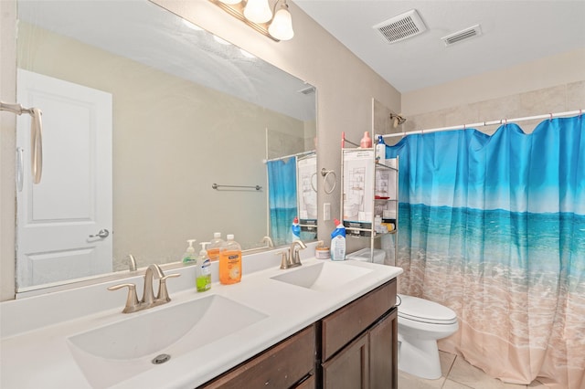 bathroom featuring toilet, visible vents, a sink, and tile patterned floors