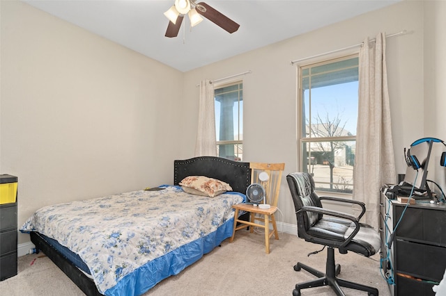 carpeted bedroom with ceiling fan and baseboards