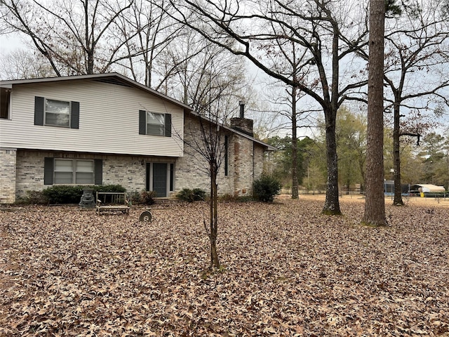 view of front of home with brick siding and a chimney