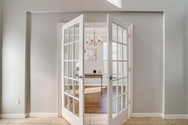 doorway with light tile patterned flooring, french doors, and a chandelier