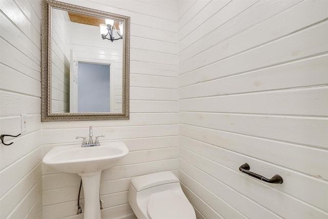 bathroom with toilet and wooden walls