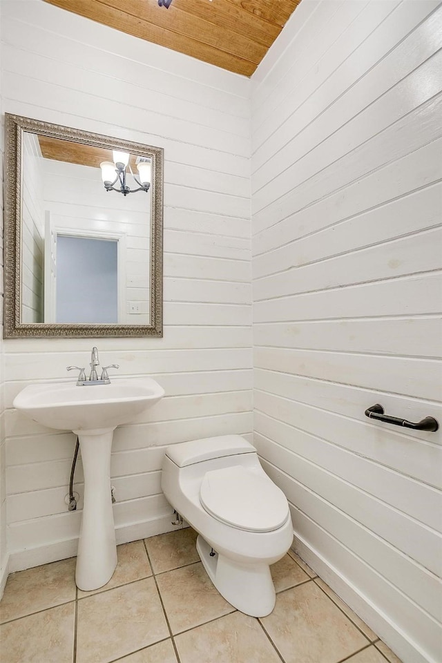 bathroom featuring toilet, wooden walls, tile patterned floors, and wood ceiling