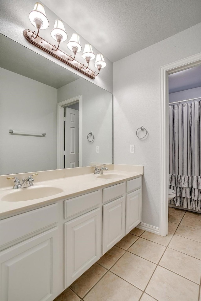 bathroom featuring a textured ceiling, tile patterned flooring, vanity, and toilet