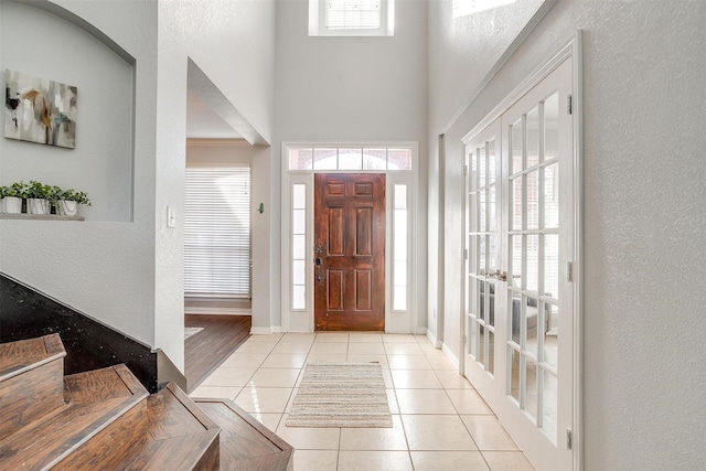 entryway with a high ceiling and light tile patterned floors