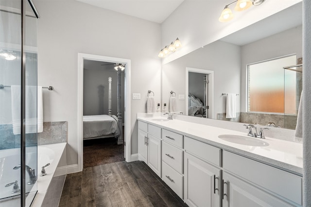 bathroom with wood-type flooring, vanity, and a washtub