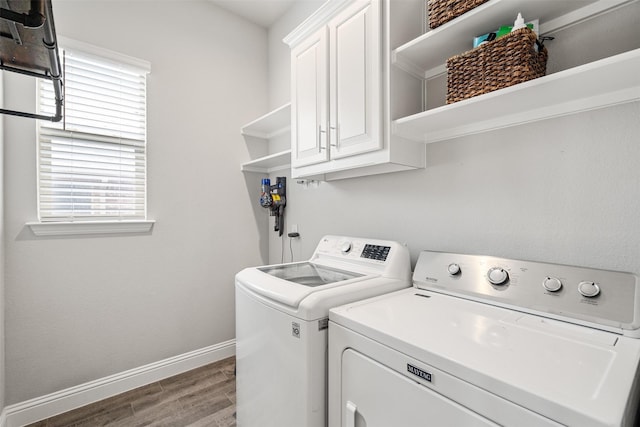 laundry room featuring cabinets, washing machine and dryer, and hardwood / wood-style flooring