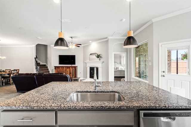 kitchen featuring sink, hanging light fixtures, dark stone countertops, dishwasher, and a kitchen island with sink