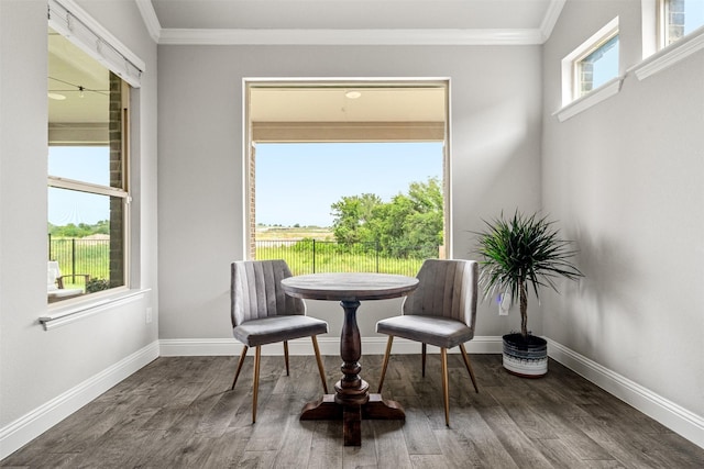 sitting room with ornamental molding and dark wood-type flooring