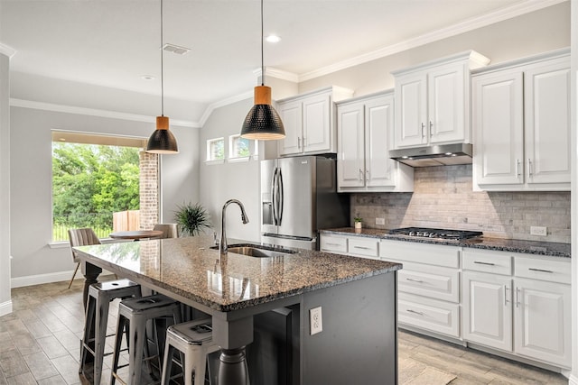 14872 Gladstone Dr, Aledo, TX 76008 - kitchen featuring ornamental molding, an island with sink, under cabinet range hood, a sink, and stainless steel appliances