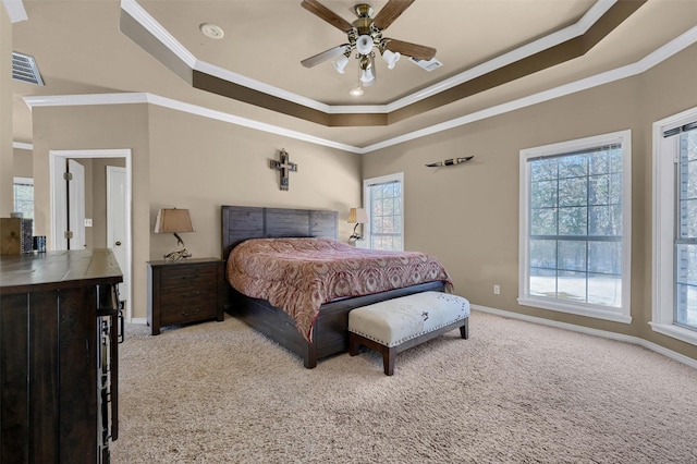 bedroom with light colored carpet, ceiling fan, a tray ceiling, and crown molding