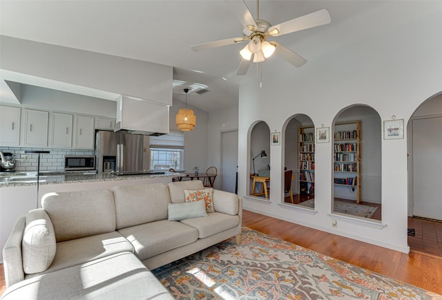 living room featuring vaulted ceiling, ceiling fan, and light hardwood / wood-style floors