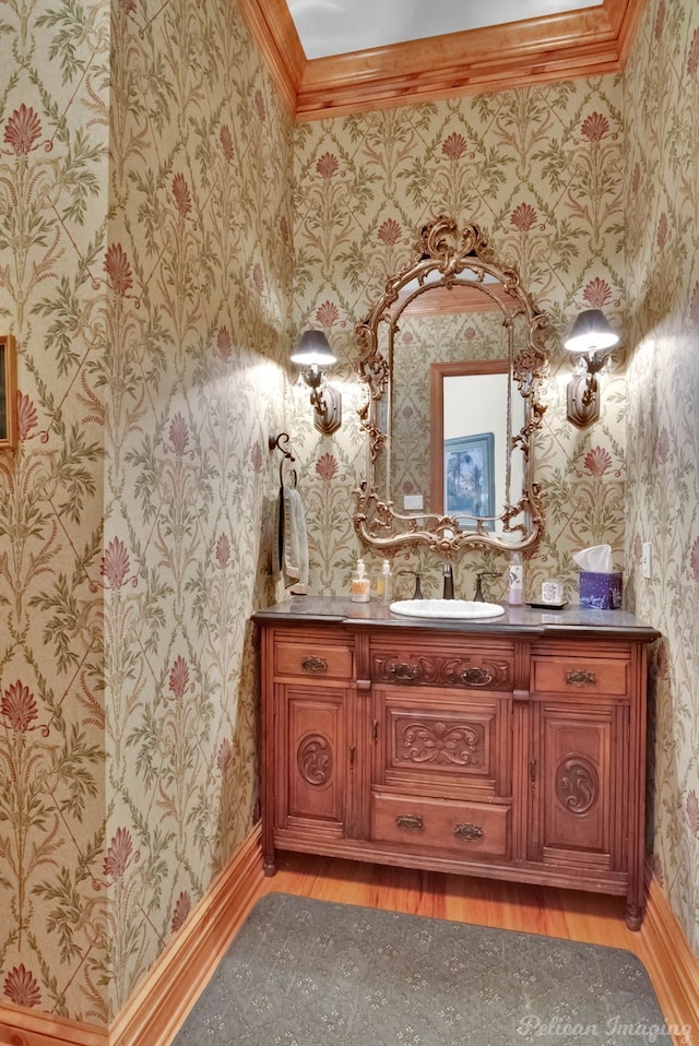 bathroom featuring hardwood / wood-style flooring, ornamental molding, and vanity