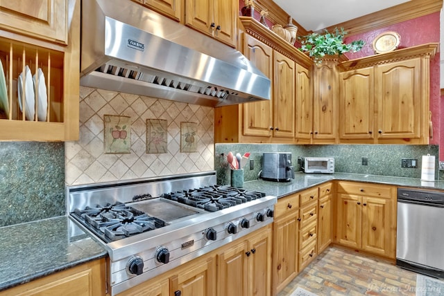 kitchen with dark stone counters, stainless steel gas stovetop, backsplash, and ventilation hood