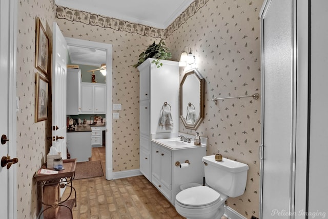 bathroom featuring toilet, ceiling fan, ornamental molding, and vanity