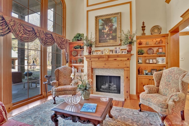 sitting room with a towering ceiling and light hardwood / wood-style floors