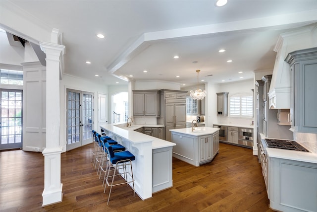 kitchen featuring pendant lighting, gray cabinets, a large island, and tasteful backsplash