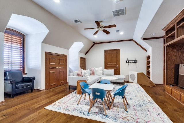 living room with ceiling fan, vaulted ceiling, and dark wood-type flooring