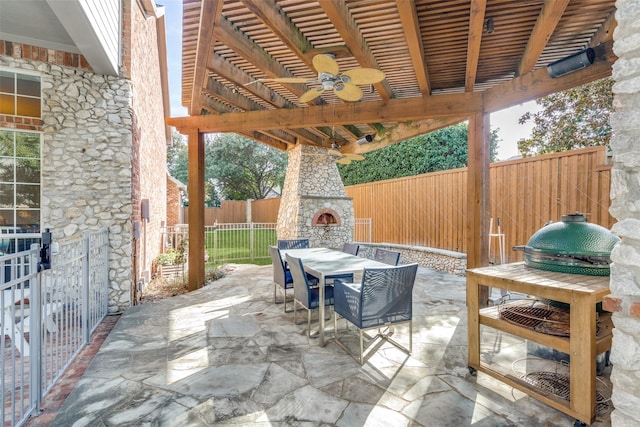 view of patio / terrace featuring ceiling fan and an outdoor stone fireplace