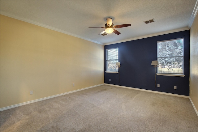 carpeted empty room featuring a healthy amount of sunlight, ceiling fan, and crown molding