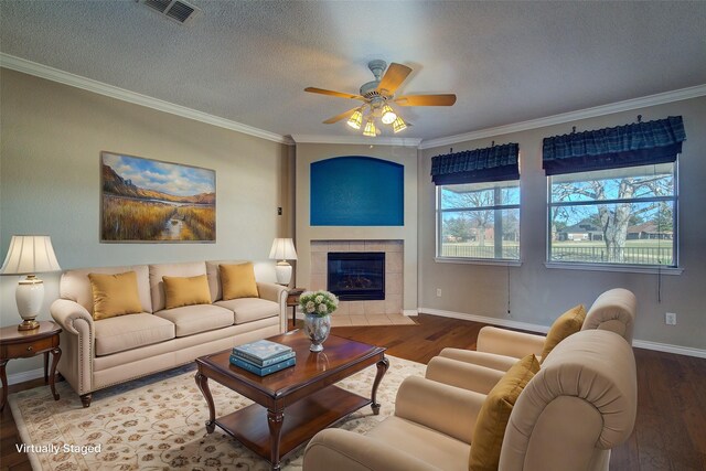 unfurnished living room featuring ornamental molding, a fireplace, ceiling fan, and light wood-type flooring