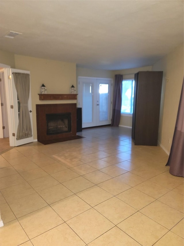 unfurnished living room featuring french doors and light tile patterned flooring