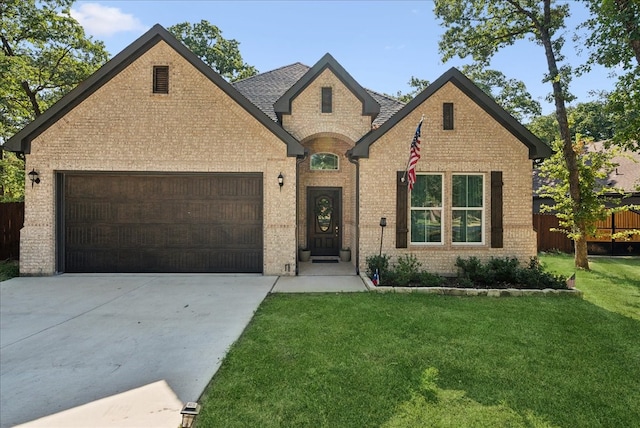 french provincial home with a front yard and a garage