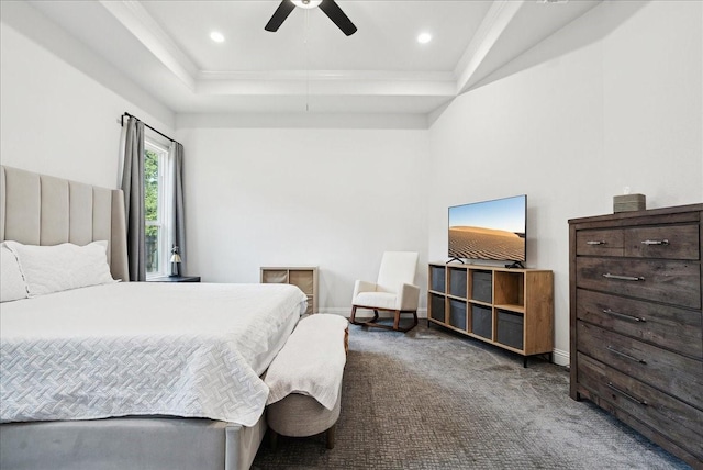 bedroom featuring ceiling fan, a raised ceiling, and dark carpet