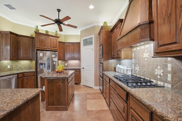 kitchen with backsplash, dark stone countertops, a center island, custom exhaust hood, and appliances with stainless steel finishes