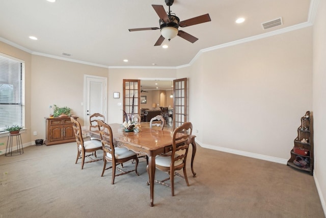 dining room with ceiling fan, ornamental molding, light colored carpet, and french doors