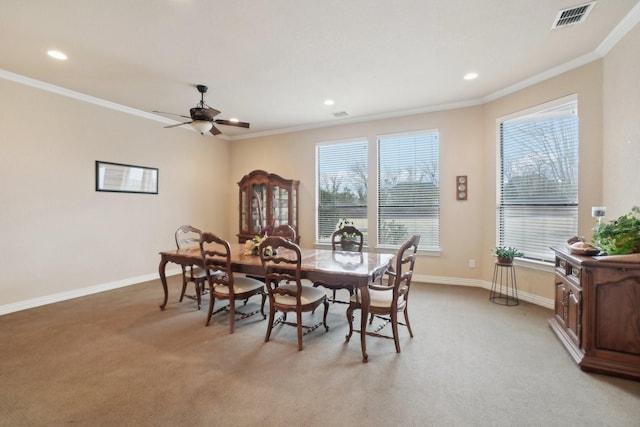 dining area with ceiling fan, light carpet, and ornamental molding