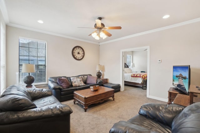 carpeted living room with ceiling fan and ornamental molding