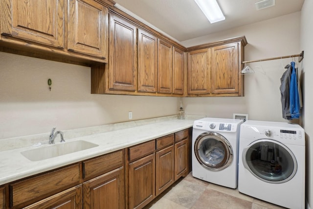 laundry area featuring cabinets, sink, and separate washer and dryer