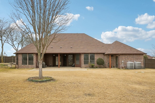 rear view of house featuring central AC unit, a yard, and a patio