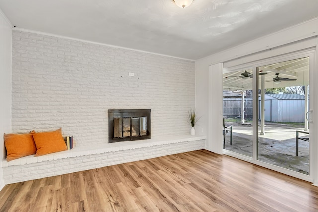 unfurnished living room featuring hardwood / wood-style floors, brick wall, and a fireplace