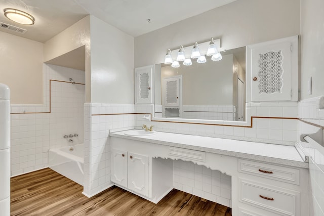 bathroom with tile walls, tub / shower combination, vanity, and hardwood / wood-style flooring