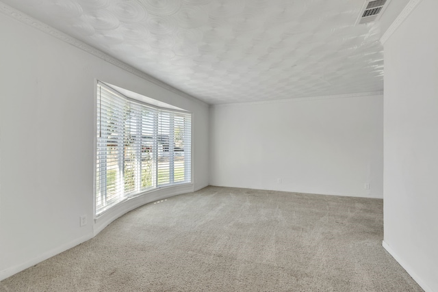 carpeted empty room featuring a textured ceiling and ornamental molding