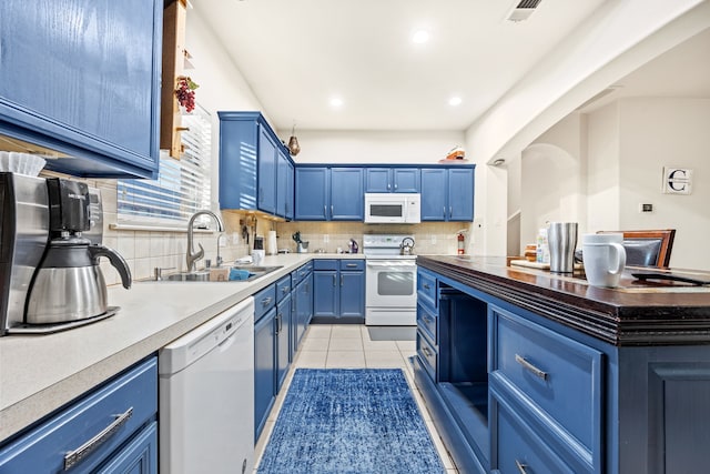 kitchen featuring white appliances, blue cabinetry, light tile patterned floors, decorative backsplash, and sink