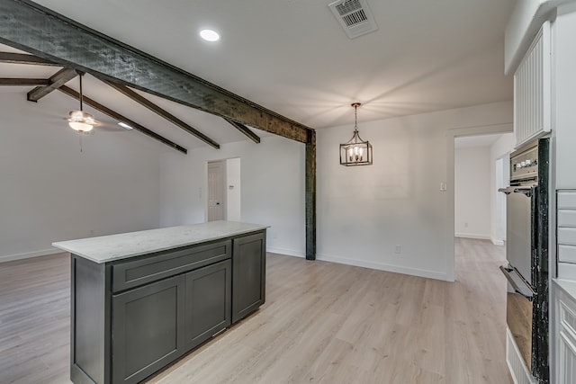 kitchen with gray cabinetry, a center island, lofted ceiling with beams, black oven, and decorative light fixtures