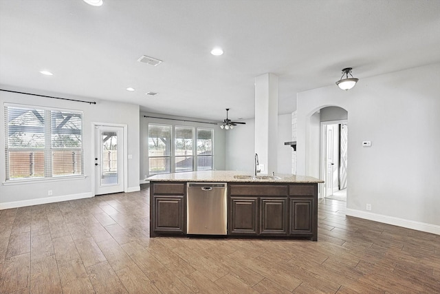 kitchen featuring an island with sink, stainless steel dishwasher, wood-type flooring, and sink