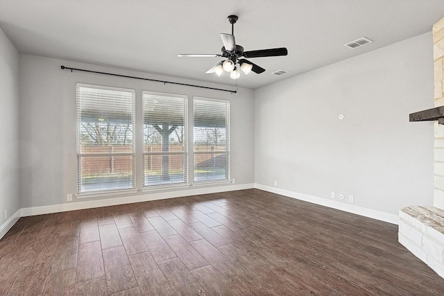 spare room with dark wood-type flooring, ceiling fan, and plenty of natural light