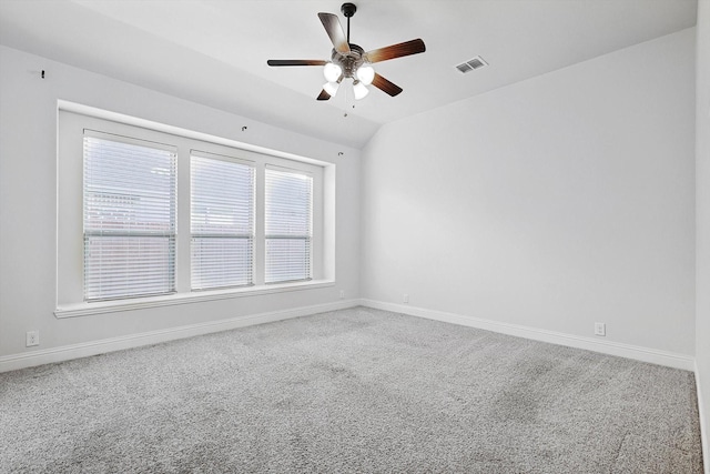 spare room featuring lofted ceiling, carpet flooring, and ceiling fan