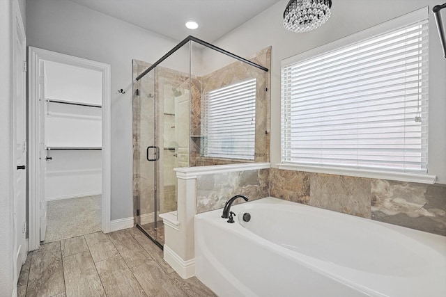 bathroom featuring an inviting chandelier and separate shower and tub