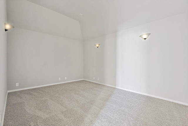 carpeted empty room featuring lofted ceiling