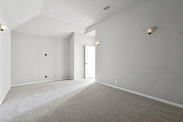 empty room featuring lofted ceiling and carpet