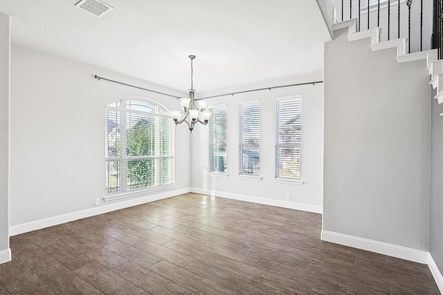 unfurnished dining area with dark hardwood / wood-style flooring and an inviting chandelier