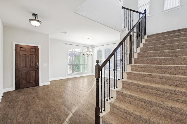 foyer with dark wood-type flooring and a chandelier