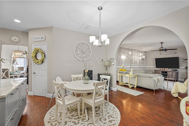 dining room with ceiling fan with notable chandelier and dark hardwood / wood-style floors