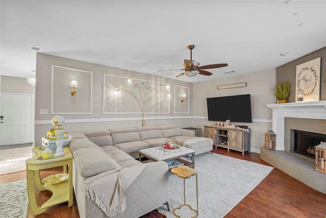 living room featuring a brick fireplace, ceiling fan, and dark hardwood / wood-style flooring